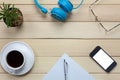 Top view notepaper,headphones,smartphone,pen,coffee ,cactus,eyeglasses on office desk background.