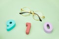 Top view of 910 numbers with eyeglasses on a light green surface Royalty Free Stock Photo