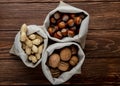 top view of nuts in sacks walnuts peanuts and hazelnuts in shell on wooden background Royalty Free Stock Photo