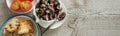 Top view of octopus salad with slices of toasted baguette and tomatoes on rustic wooden background