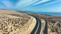 Top view od a curvy road across the sandy dunes of Fuerteventura islands.