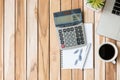 Top view Office desk with calculator, pen, blank notebook, paperclip, computer laptop and coffee cup  on wood table background. Royalty Free Stock Photo