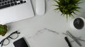 Top view of office desk with laptop, mouse, smart phone, coffee cup and glasses on marble background. Royalty Free Stock Photo