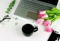 Top view office feminine desk and bouquet pink tulips