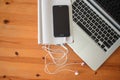 Top view of an office mock up with a laptop, blank mobile phone with headsets, and blank notebook Royalty Free Stock Photo