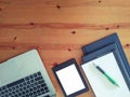 Top view of an office mock up with a laptop, blank tablet, and blank notebooks with a pen Royalty Free Stock Photo