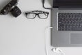 Top view office table concept with camera, laptop notebook, glasses and earphone smartphone on grey table background. Flat lay wi Royalty Free Stock Photo