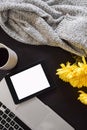 Top view of an office table mock up with a laptop, tablet, cup of coffee, yellow flowers and a cardigan sweater Royalty Free Stock Photo