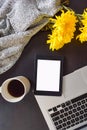 Top view of an office table mock up with a laptop, tablet, cup of coffee, yellow flowers and a cardigan sweater Royalty Free Stock Photo