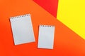 Top view of office tools with blank notebook on orange, yellow and red background. Space for text Royalty Free Stock Photo