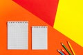 Top view of office tools with blank notebook on orange, yellow and red background. Space for text Royalty Free Stock Photo