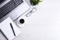 Top view of office work space, wooden desk table with laptop notebook,keyboard ,pen,eyeglasses,phone,notebook and cup of coffee. Royalty Free Stock Photo