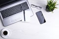 Top view of office work space, wooden desk table with laptop notebook,keyboard ,pen,eyeglasses,phone,notebook and cup of coffee. Royalty Free Stock Photo