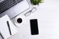 Top view of office work space, wooden desk table with laptop notebook,keyboard ,pen,eyeglasses,phone,notebook and cup of coffee. Royalty Free Stock Photo