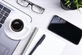 Top view of office work space, wooden desk table with laptop notebook,keyboard ,pen,eyeglasses,phone,notebook and cup of coffee. Royalty Free Stock Photo