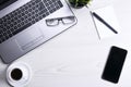 Top view of office work space, wooden desk table with laptop notebook,keyboard ,pen,eyeglasses,phone,notebook and cup of coffee. Royalty Free Stock Photo