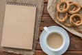 Top view office workplace: ÃÂ¡ardboard notepad with bagels and coffee on wooden table