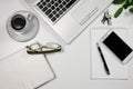 Top view of office workplace with laptop, notepad, keys, glasses, phone, on the white desk. Royalty Free Stock Photo