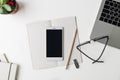 Top view of office workplace. White desk with copy space. Flat lay view on table with laptop, pencil, phone, notebook, glasses Royalty Free Stock Photo