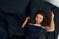 Top view og woman that lying down on bed. Interior and design of beautiful modern bedroom at daytime Royalty Free Stock Photo