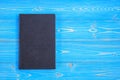 Old black book on wooden plank background. Blank empty cover for Royalty Free Stock Photo