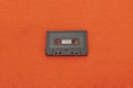 Top View of an old black cassette over a orange cloth Royalty Free Stock Photo