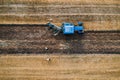 Top view of old blue belarus tractor ploughing fields.