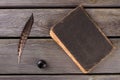 Top view old book with quill and inkpot.