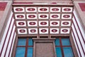 A top view of an old building with interesting architecture. TIles on top and blue windows are on the front. Avant-garde style