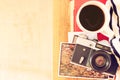 Top view of old camera, cup of coffe and stack of photos. filtered image. travel or vacation concept