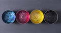 Top view of old CMYK paint cans on dark background. Colorful background. Royalty Free Stock Photo