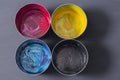 Top view of old CMYK paint cans on dark background. Colorful background. Royalty Free Stock Photo