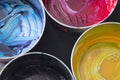 Top view of old CMYK paint cans on dark background. Colorful background. Royalty Free Stock Photo