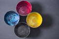 Top view of old CMYK paint cans on dark background. Colorful background. Royalty Free Stock Photo