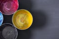 Top view of old CMYK paint cans on dark background. Colorful background. Royalty Free Stock Photo