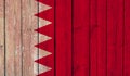 Top view of Old Painted Flag of Bahrain on Dark Wooden Fence, wall. patriot and travel concept. no flagpole. Flag background.