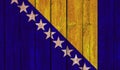 Top view of Old Painted Flag of Bosnia and Herzegovina on Dark Wooden Fence, wall. patriot and travel concept. no flagpole. Flag Royalty Free Stock Photo