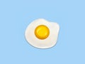 Fried egg isolated on blue background.