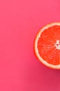 Top view of an one grapefruit slice on bright background in pink color. A saturated citrus texture image Royalty Free Stock Photo