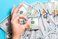 Top view of one hundred dollar bills in one hand and showing okay gesture with another hand on colorful background. Prosperity and Royalty Free Stock Photo