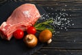 Top view of one pieces raw pork chop steaks with cherry tomatoes Champignon mushrooms on a black stone cutting board Royalty Free Stock Photo