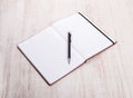 Top view of open book with pen on wooden table Royalty Free Stock Photo