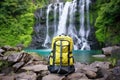 top view of open camping backpack by waterfall