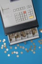 Top view of an open cash register with a large number of metal coins