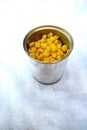 Top view of open corn can on a white tablecloth Royalty Free Stock Photo