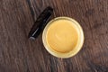 Top view of open glass jar with Dijon mustard and black lid on wooden background. Royalty Free Stock Photo