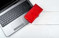 Top view of open laptop computer and red gift box on wooden table, copy space. Flat lay. Online shopping,  holidays sales. Royalty Free Stock Photo