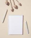 Top view of open notebook with blank pages and dry plat poppy on table, autumn concept. Creative workspace Royalty Free Stock Photo