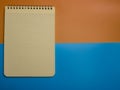 Top view of an open notebook with a pencil and an eraser on a blue-yellow background.