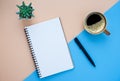 Top view of open school notebook with blank pages and pen with coffee cup on light-blue brown two-tone background. Royalty Free Stock Photo
